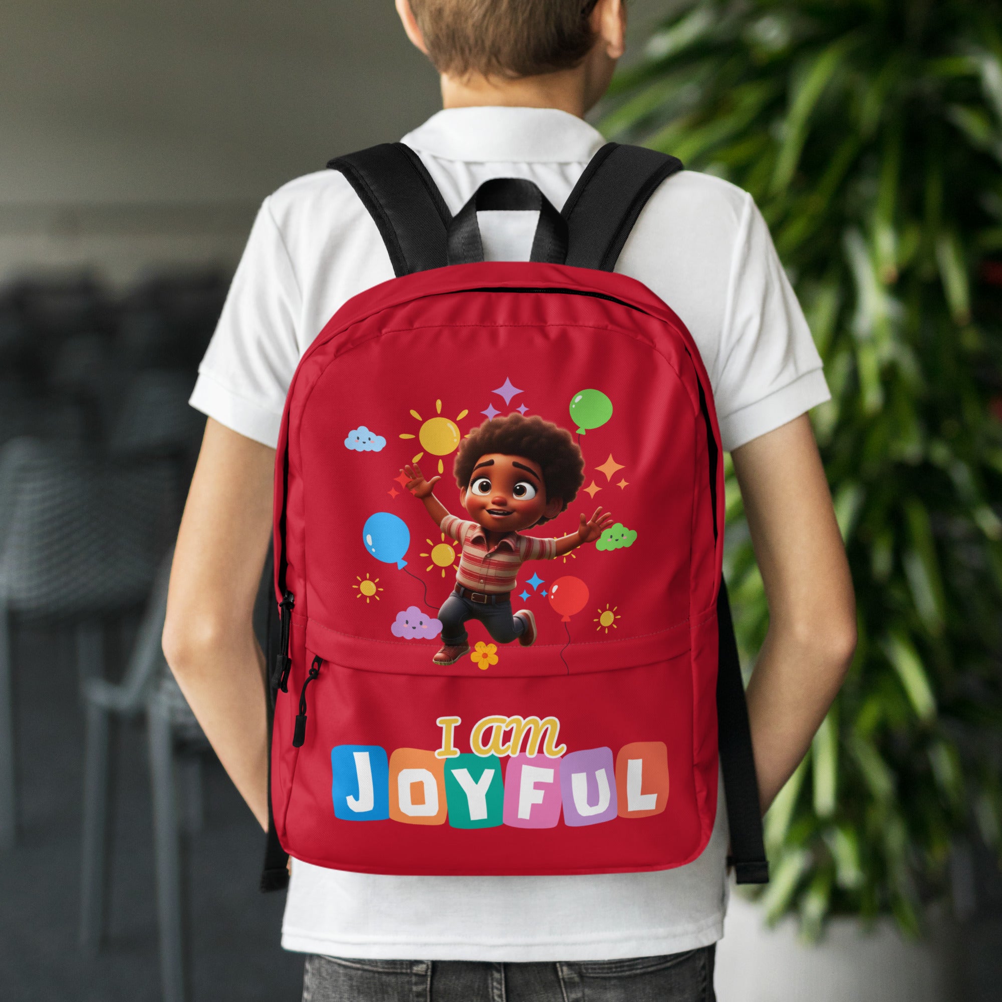 Red backpack with all-over joyful print, designed for kids by Kingdom Kids Club, shown with white back and playful pattern.