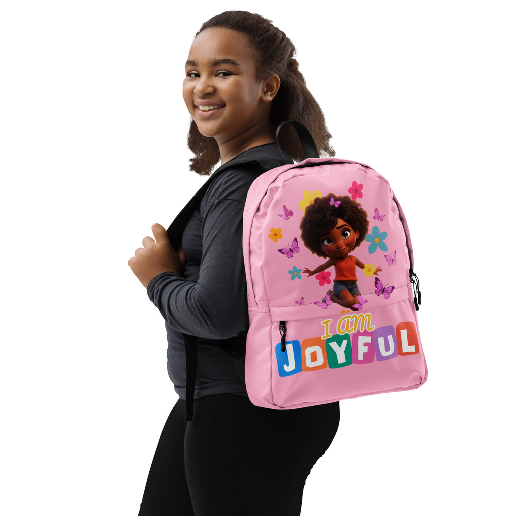 Pink Kingdom Kids Club backpack with colorful "I Am Joyful" all-over print, featuring sturdy straps and a spacious main compartment.